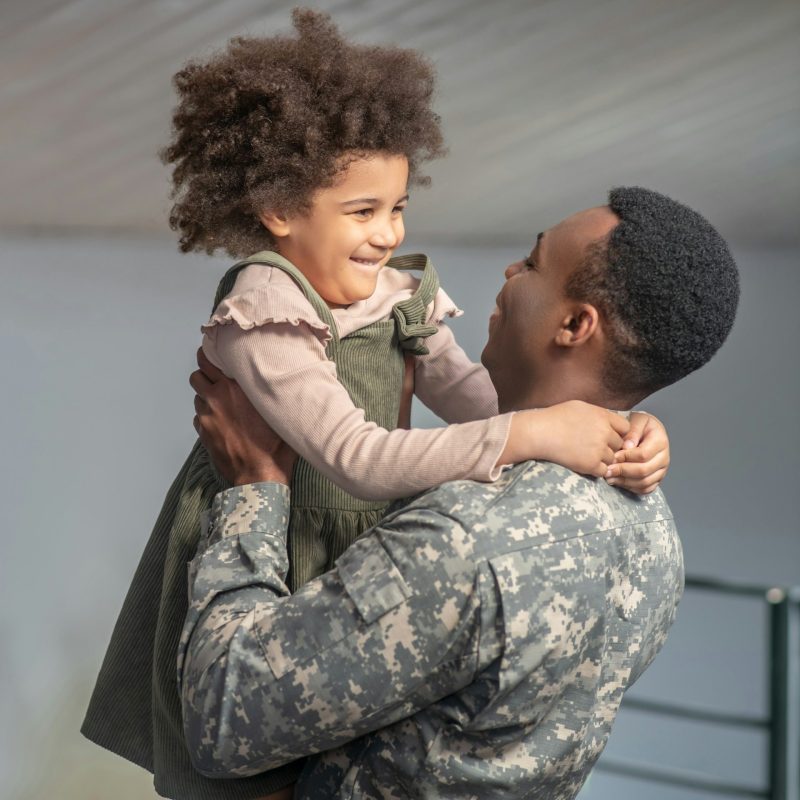 Military man in uniform holding his daughter