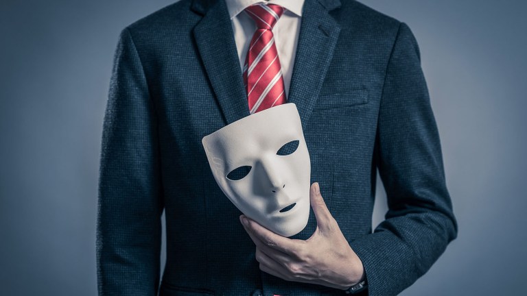 Person in a suit holding a theater mask - this is meant to represent importer scams.