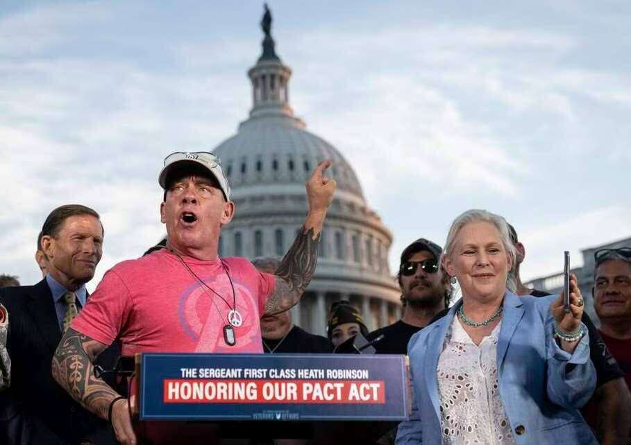 A group of people standing in front of the capitol building celebrating the passage of the PACT Act.