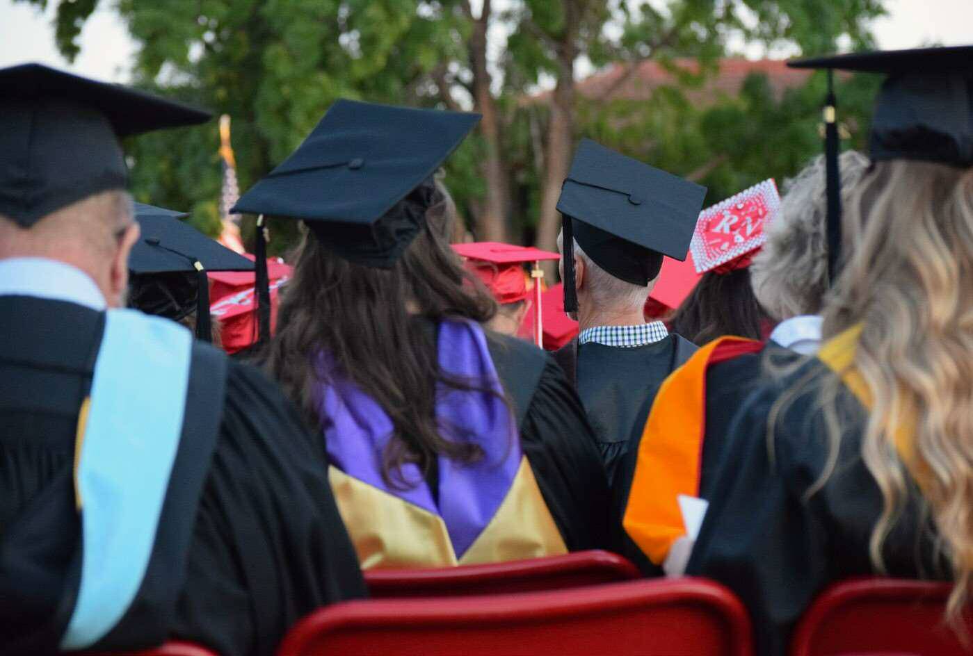 People at a commencement ceremony wearing graduation caps.