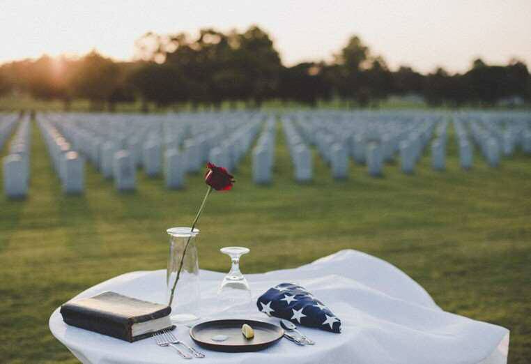 Empty table near a graveyard, set to remember a missing family member.